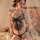 Woman wearing mannyqing butterfly sheer lace bralette & panty set, sensual matching sleepwear with floral backdrop.