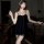 Woman wearing mannyqing black halter mesh slip dress with low-cut neckline and floral detail, posing indoors.