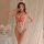 A woman poses wearing a red and white lace bodysuit with bows, featuring a nurse cap. the design includes heart patterns and ...