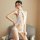 A woman poses confidently wearing a white, lace-trimmed sleepwear set with cutouts, featuring a halter neck design and vintag...
