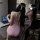 A woman wearing a pink mannyqing pure-yu rose mesh bodycon dress sits by a laptop, showcasing its floral sheer lace design. t...