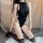 Woman kneeling in black mannyqing seductive lace bodysuit with open-crotch design, sheer lace panels, and thigh-high stocking...