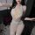 Woman wearing mannyqing sexy deep v lace bodysuit with sheer mesh, cross-back design, and open-crotch detail, posing beside r...