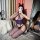 A woman poses in a mirror wearing a purple mannyqing sheer lace bodysuit set, featuring open-crotch design and fishnet stocki...