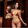 Woman wearing red mannyqing bikini set with butterfly hip tie, featuring halter top and side-tie bottoms in a cozy indoor set...