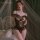 Woman modeling manyan lace open-crotch bodysuit, sheer sensual sleepwear for date night and intimate moments.