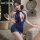 Woman in shimmer blue halter bodycon dress, backless design, holding wine glass—sexy nightclub outfit by manyan.