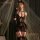 Model wearing manyan pure & tempting black lace bodysuit with sheer panels, garters, and bunny ears in romantic setting.