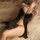 Woman wearing black manyan sheer lace sleep dress set with open front and adjustable straps on bed.