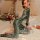 Woman wearing mei xing qing snake-print lingerie set, kneeling on bed with floral decor and soft lighting.