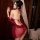 A woman poses elegantly in a red meimei sensual chinese-style embroidered deep v halter bodysuit, featuring vintage belly dan...
