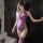 Woman wearing purple meiyoujia sexy lace halter bodysuit with sheer panels and matching thigh-highs, leaning against dark wal...