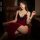 Elegant red velvet sleep dress featuring deep v-neckline, intricate lace detailing, high slit design, and striking red cinnab...