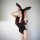 Woman wearing black midnight temptation bunny girl bodysuit with deep v neckline, bunny ears headband, and white collar.
