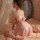 A woman poses elegantly in a sheer pink sleepwear set by minaer, featuring backless straps and a bow detail, complemented by ...