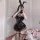 A woman poses with a mirror wearing a black pu lace-up halter top, batwing mini skirt, and bunny ears, perfect for cosplay.
