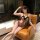 Woman in mist temptation lingerie set - pure & alluring catwoman style sexy sleepwear for women, posing on a leather chair.