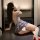 Woman wearing mist temptation lingerie set – sheer mesh sleepwear with floral pattern, seated on table in sensual pose.