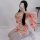 A woman poses with a smartphone, wearing a pink misty romance kimono lingerie set featuring cute cat designs. the outfit incl...