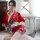 A woman sits gracefully wearing a vibrant red moxin japanese-style lingerie set, featuring floral patterns and elegant design...