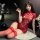 A woman poses elegantly in a red lace-trimmed cheongsam lingerie set, featuring sheer fabric and tie details, perfect for vin...