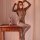 Woman wearing a mystique leopard lace bodysuit, a seductive backless mesh lingerie with sheer stockings, posing elegantly.