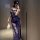 Woman wearing navy blue lace sleepwear, holding a feather accessory, in a mirror selfie.