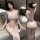 Woman modeling white lace night desire lingerie set with bow details, featuring bra, panty, and garter straps in bedroom sett...
