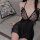 Woman wearing black sheer butterfly lace lingerie set with pearl necklace, elegant nightwear for intimate moments.