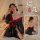 A woman wearing a black japanese-style nightwear set with floral patterns, featuring red accents and sheer fabric, designed f...