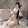 A woman poses in a bathroom, wearing a night silk elegant chinese style peony qipao dress. the flowing tassels and soft vinta...