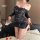 Woman modeling a navy blue lace bodycon mini dress with sheer long sleeves and an off-shoulder design, styled as a sexy secre...