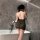 Woman wearing night silk lace cheongsam lingerie set, back view showing sheer green lace design in modern bathroom.