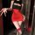 Woman wearing red and black night-silk seductive secretary outfit with lace garter, posing in dimly lit room.