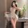 Woman wearing sheer white butterfly halter nightgown with lace details, backless design, and flowing mesh skirt in elegant be...