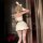 Woman wearing white bunny girl lingerie set with ruffled skirt, thigh-high stockings, and fluffy ears—modest yet sexy sleepwe...