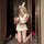 Woman kneeling in white bunny girl lingerie set with ears, crop top, ruffled skirt, and lace garter stockings.