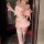 Woman wearing pink night-silk sensual bunny girl lingerie set with ruffled skirt, gloves, and thigh-high stockings.