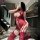 Woman in red night silk sensual lace bodysuit with sheer mesh, open-crotch thong, straps, and stockings, posing indoors.