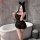 A woman poses by a bathtub wearing a black lace dress with cat ears, featuring sheer fabric and ruffled hem. the design highl...