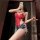 Woman in red lace bodysuit with denim shorts, holding wine glass and phone. night-silk sensual open-crotch lace bodysuit set.