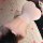 Woman wearing backless pink night silk sensual sheer bodycon nightdress with chest cutout, lying on bed with rose petals.