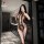 Woman in black sheer mesh bodysuit with open-crotch design, posing in modern kitchen. night silk sensual sheer bodysuit for w...