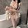 A woman poses in a bathroom wearing a pink maid costume with ruffled details, holding a plush rabbit toy. the outfit features...