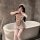 A woman poses playfully behind a bathtub wearing a night silk sexy maid costume. the outfit features ruffled details, a cute ...