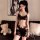 A woman models a black lace bodysuit with sheer fabric and floral patterns, featuring an open-crotch design, perfect for inti...