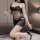 A woman poses elegantly in a black lace bodysuit, featuring sheer fabric and an open-crotch design, holding a glass of wine w...