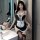 A woman poses in a black and white maid costume featuring lace details, sheer stockings, and a corset-style design, perfect f...