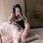 A person poses with a teddy bear while wearing a night-suit set featuring a sailor uniform design, complete with fishnet stoc...