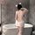 Woman wearing white lace-back sleepwear set with cat ears, posing by bathtub — night temptation seductive couples intimate ou...
